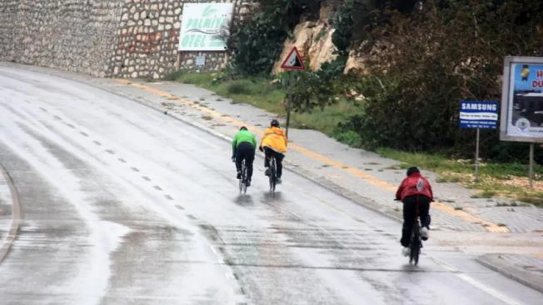Yağmurda bisiklet sürüp denize girdiler